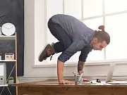 Short break for yoga in office. Flexible man practicing yoga at workplace, making balance exercise on desk, copy space. Active employee at work, healthy lifestyle concept